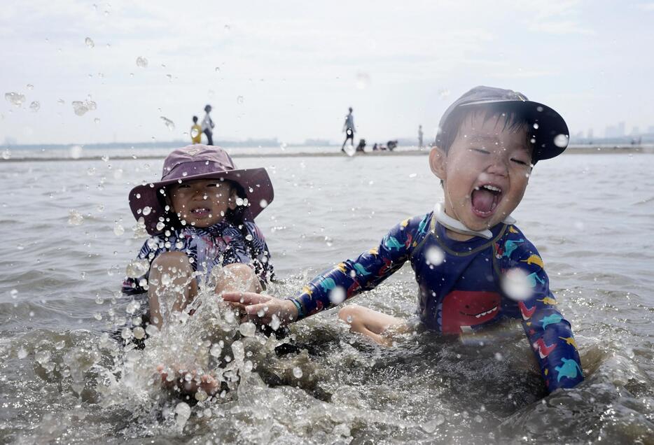 厳しい暑さの中、水際で遊ぶ子どもたち＝7日午後、東京都江戸川区