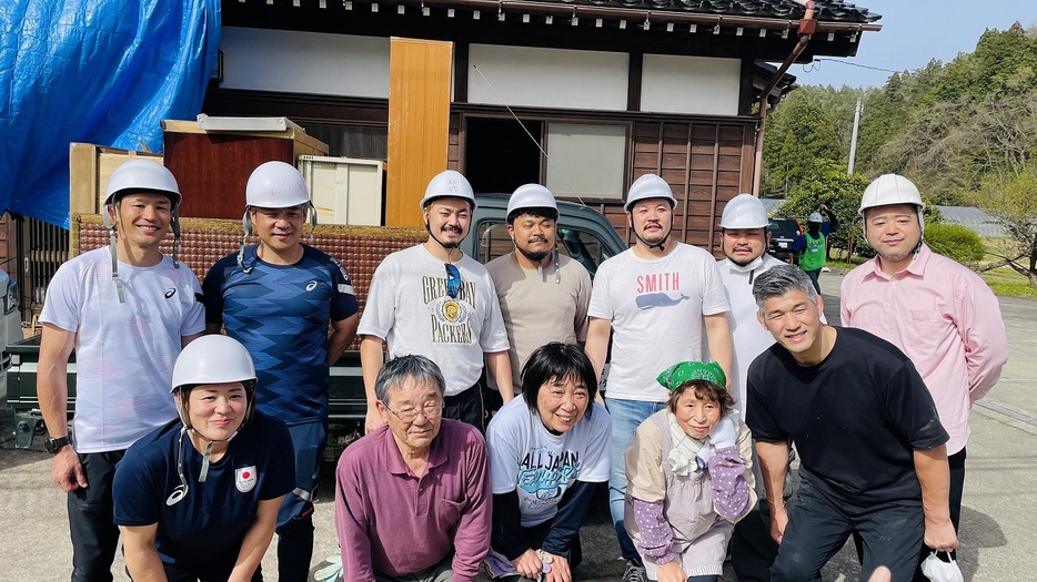 能登で瓦礫処理ボランティアなどをおこなった。後列左から廣瀬俊朗さん、最上紘太さん、コーラスグループ「QUMANOMI」のメンバーら。前列左から、谷本歩実さん、被災者の皆さん、井上康生さん（写真提供：スポーツの力で能登応援）