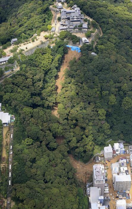 松山城（上）がある山の斜面で発生した土砂崩れ現場＝12日、松山市