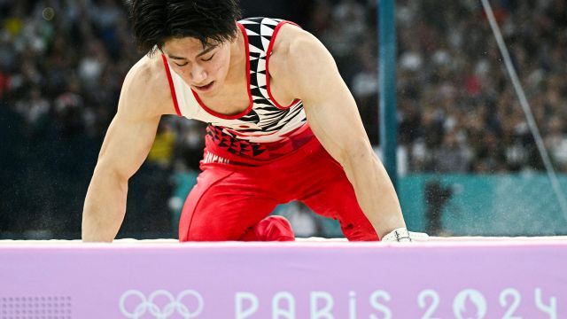 鉄棒の最後の着地で両手をつく橋本大輝選手(写真:ＡＦＰ/ アフロ)