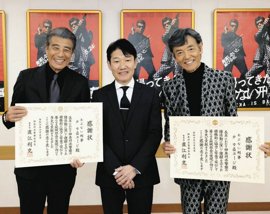 神奈川県警の荻原英人総務部長（中央）から感謝状を受け取った舘ひろし（左）と柴田恭兵