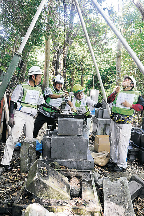 墓石の仮復旧に取り組む職人＝七尾市小島町