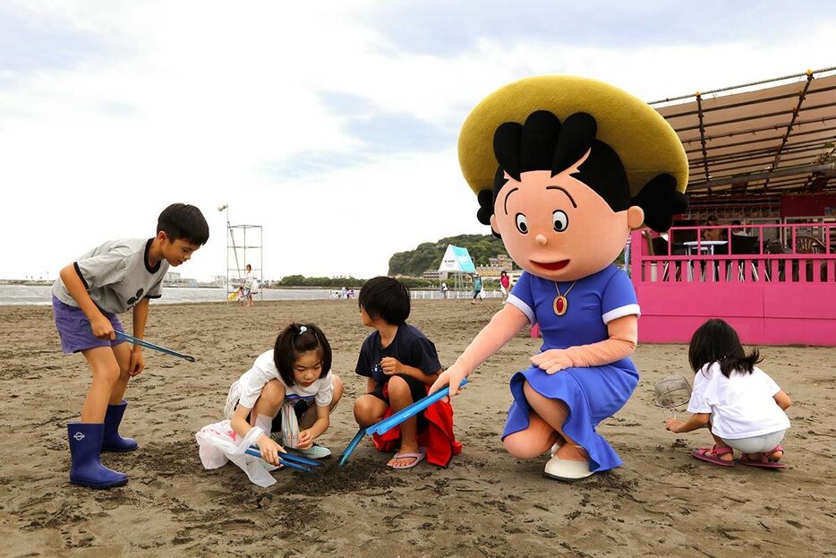サザエさんと一緒に子どもたちも砂浜に落ちているプラスチックごみなどを拾った＝１日、藤沢市の片瀬海岸東浜