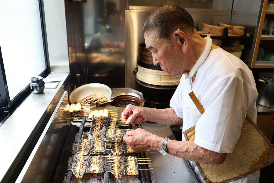 丑の日に向けて、次々うなぎを焼く男性（写真・時事通信）