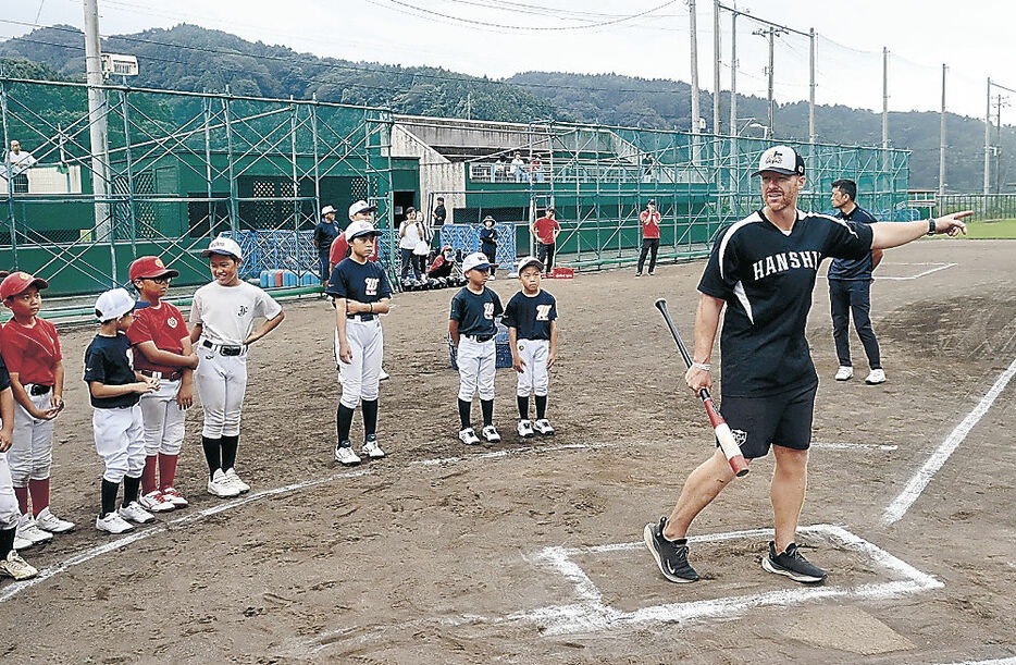 児童にバッティングを教えるマートンさん＝輪島市門前野球場