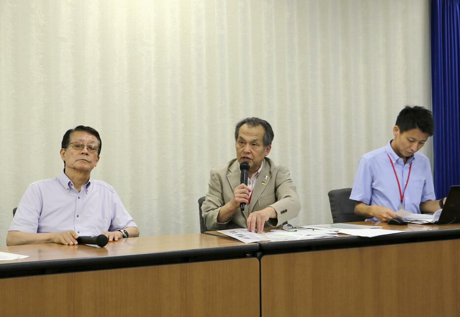 記者会見する「きょうされん」の小野浩常任理事（中央）＝30日午後、厚労省