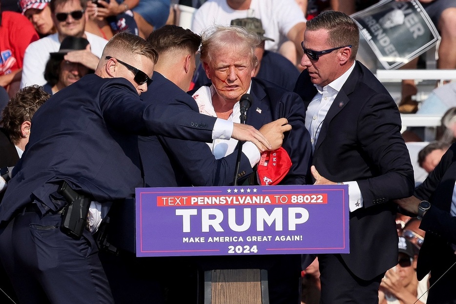 7月13日、選挙集会で銃撃されたトランプ氏と駆け寄るSP（写真：ロイター/アフロ）