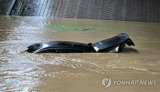 京畿道華城市で18日、冠水した道路で車が水没している（華城市自律防災団提供）＝（聯合ニュース）≪転載・転用禁止≫