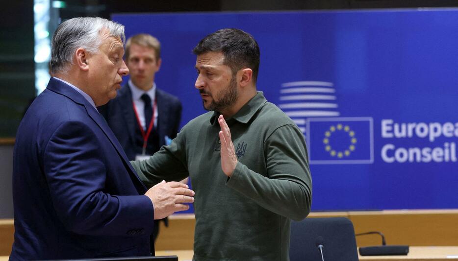 ベルギー・ブリュッセルで、ウクライナのゼレンスキー大統領（右）と話すハンガリーのオルバン首相＝6月27日（ロイター＝共同）