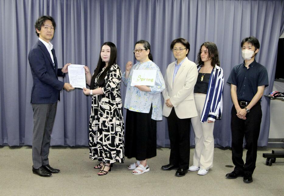 法務省の担当者（左端）に要望書を手渡す「Spring」のメンバー＝25日午前