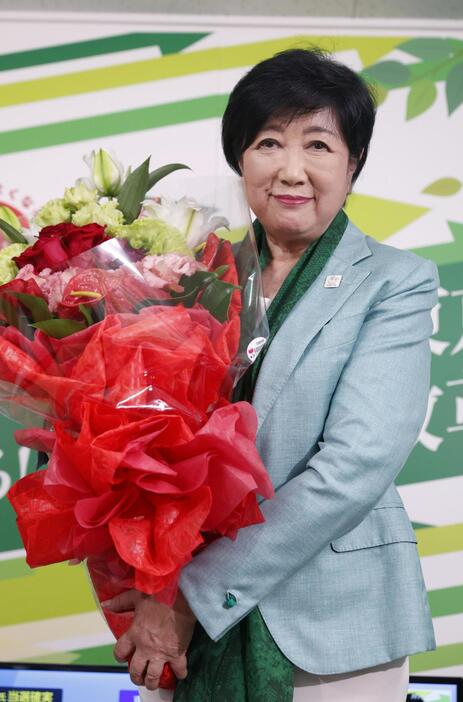 東京都知事選で3選を確実にし、花束を持つ小池百合子氏＝7日夜、東京都新宿区