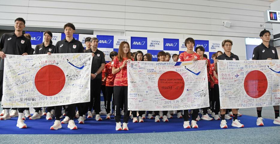 出国前に羽田空港で撮影に応じる（左から）バレーボール男子、サッカー女子、サッカー男子の日本代表＝14日