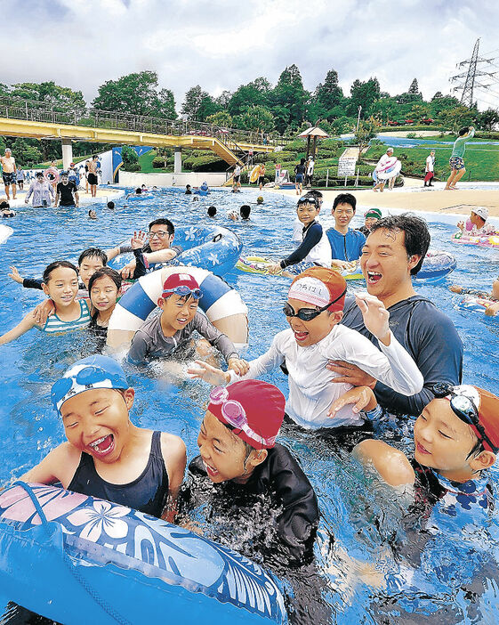 流水プールを楽しむ家族連れや子どもたち＝射水市の県民公園太閤山ランド