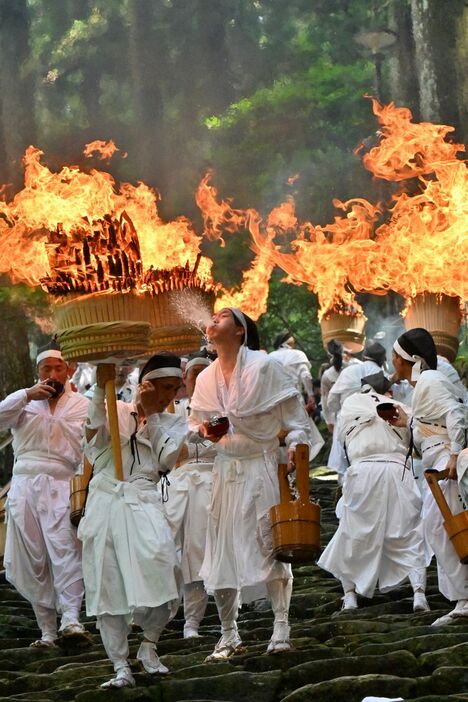 熊野那智大社の別宮「飛瀧神社」の参道を清める大たいまつの炎（14日、和歌県那智勝浦町那智山で）