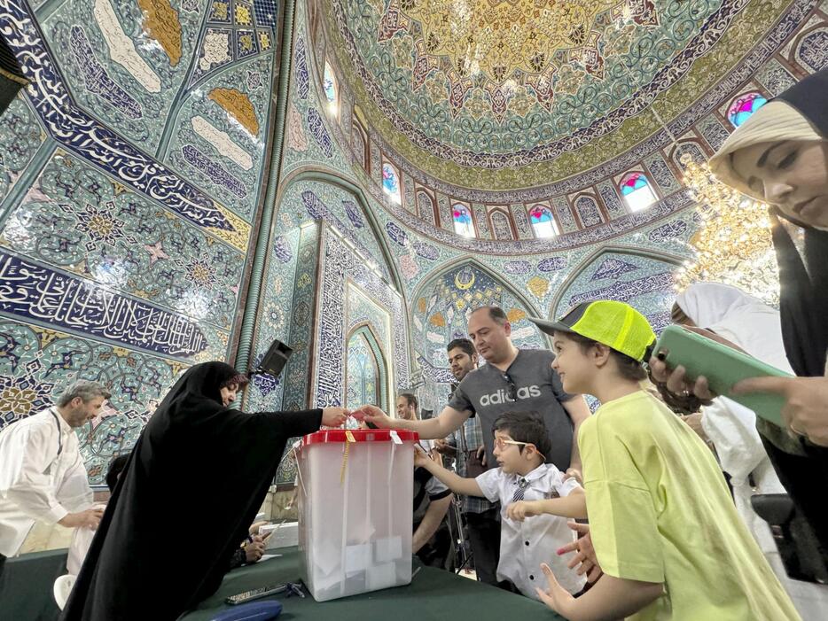 5日、イランの首都テヘランの投票所で票を投じる人々（共同）