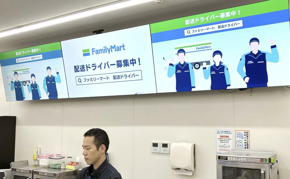 ファミリーマート店舗のデジタルサイネージに表示された配送員募集の案内＝2日、東京都中央区