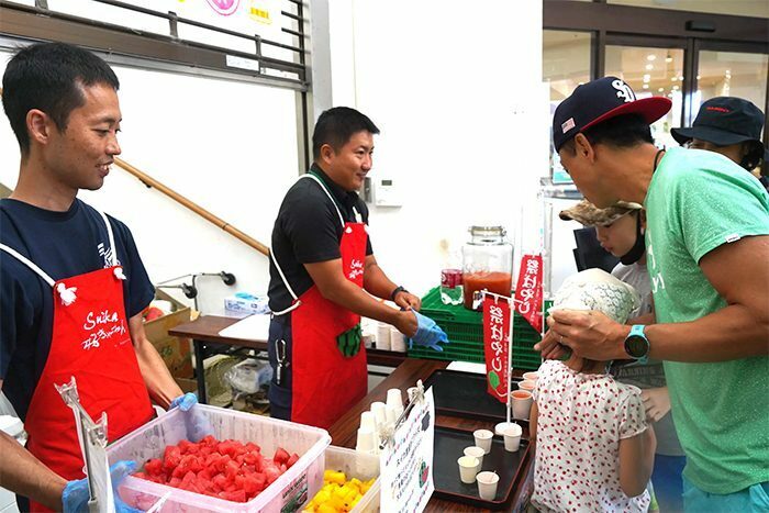 旬の味覚をPRする生産者、JA北部地区営農振興センターの職員ら＝27日、名護市のJAファーマーズマーケットやんばる