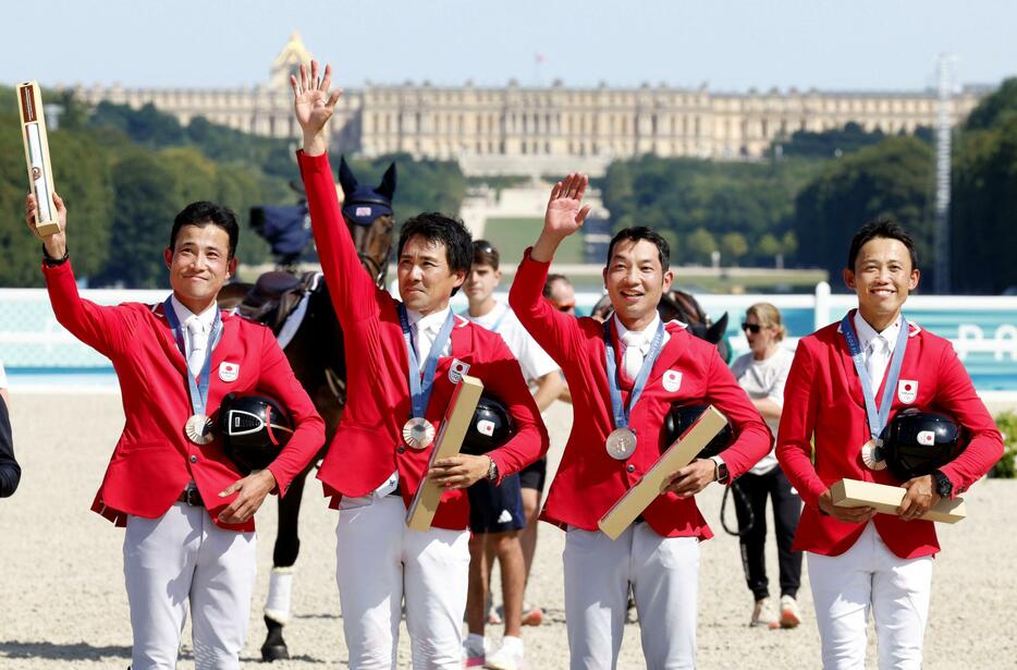 パリ五輪馬術の総合馬術団体で銅メダルを獲得し、観客の声援に応える（左から）北島隆三、大岩義明、田中利幸、戸本一真＝29日、パリ郊外（共同）