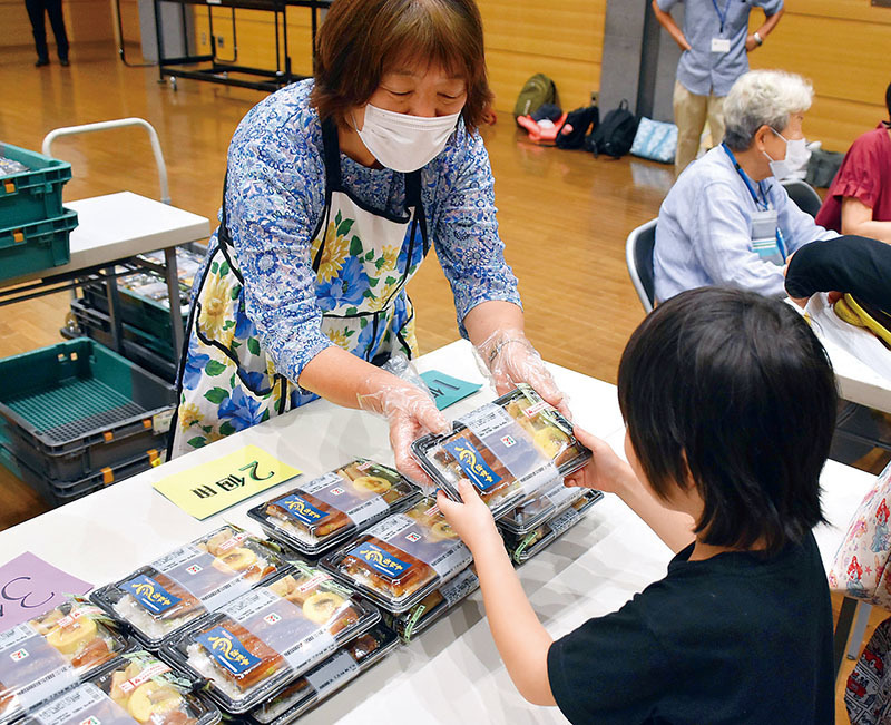 うなぎ弁当を受け取る子ども＝24日午後、杉戸町内