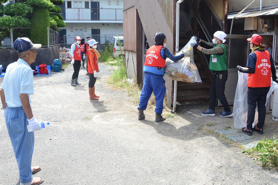 部屋から水に漬かった日用品などを運び出す災害ボランティア（中村3丁目で）