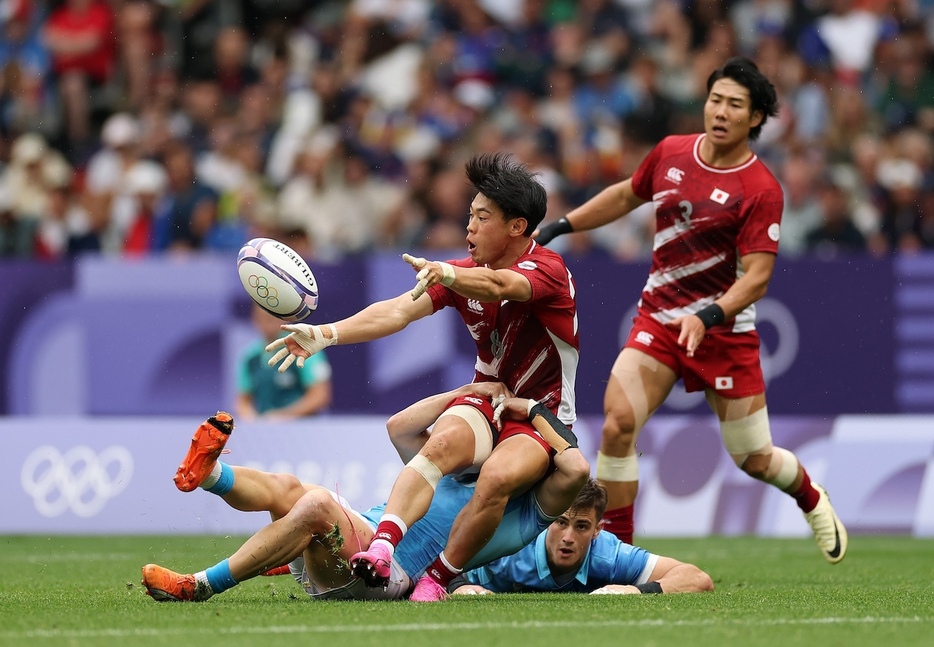 タックルを受けながらパスする野口宜裕(Photo: Getty Images)