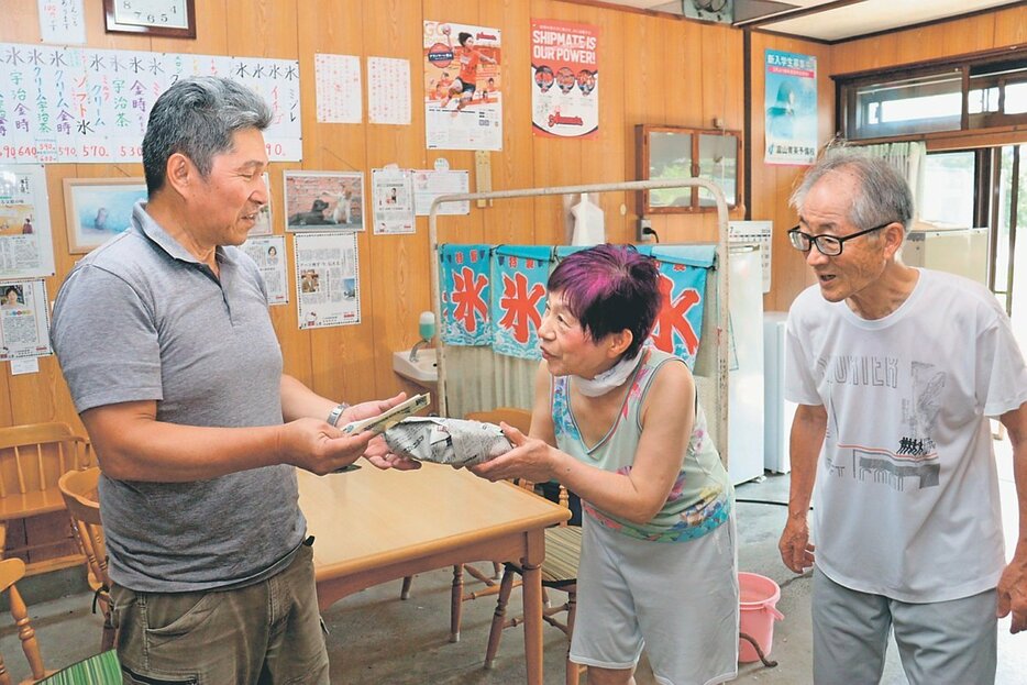 客と話す太田由美子さん（中央）と晏昇さん（右）。息の合った夫婦の会話も人気だった＝太田屋