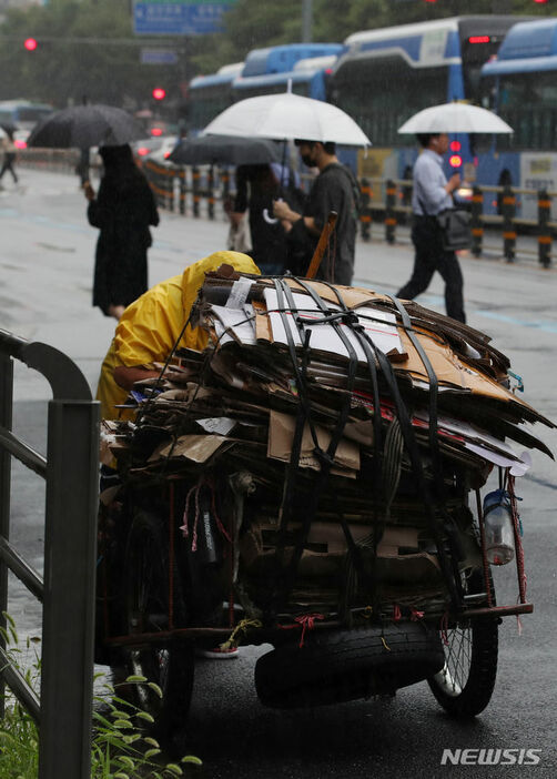 ソウル市城北区の路上で、古紙をリヤカーに積む高齢者(c)NEWSIS