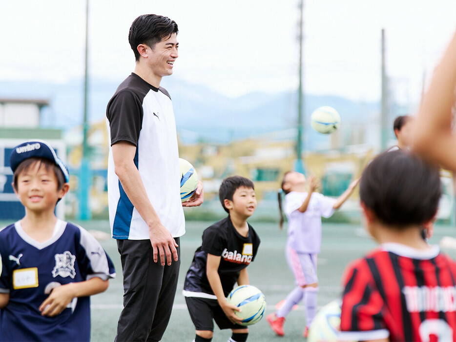 子どもたちとサッカーボールで遊ぶ谷口彰悟　photo by Shiraki Yoshikazu