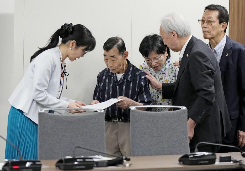 旧優生保護法を巡る最高裁判決を受け、原告の北三郎さん（仮名、左から2人目）らと面会し、要求書を受け取る加藤こども政策相（左端）＝4日午前、こども家庭庁