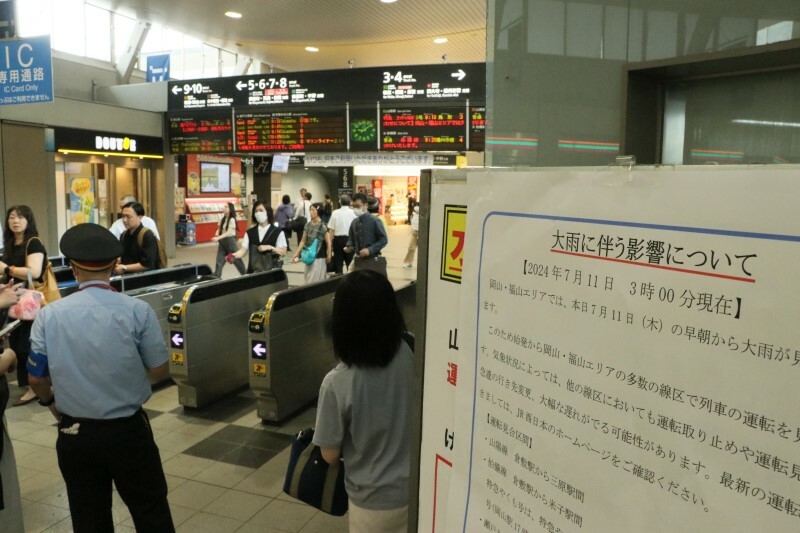 大雨に伴う運休などを知らせる掲示板が設置されたJR岡山駅の改札口＝11日午前9時9分