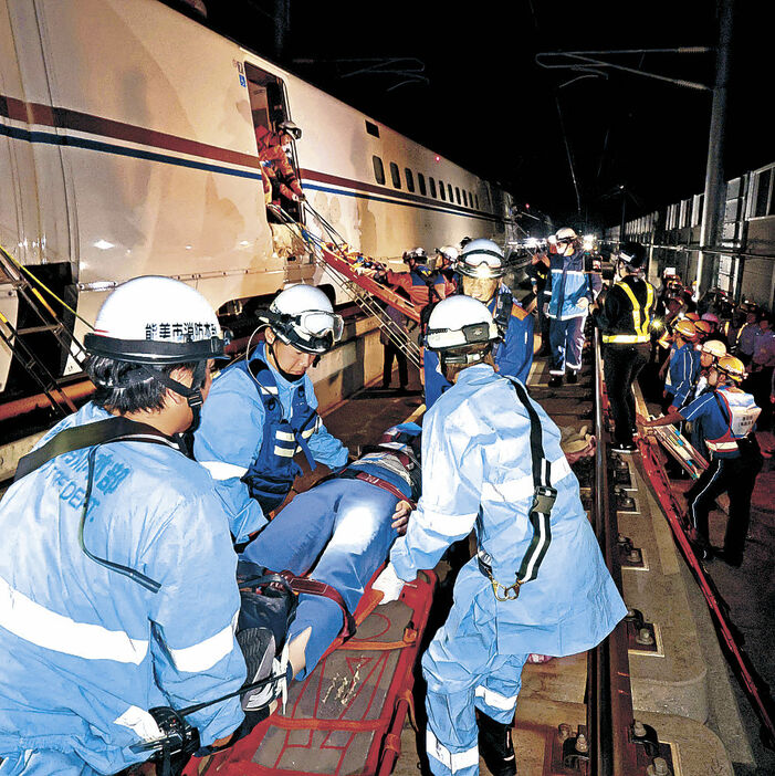 新幹線車両から、けが人を救助する参加者＝１２日午前１時３６分、小松市島町