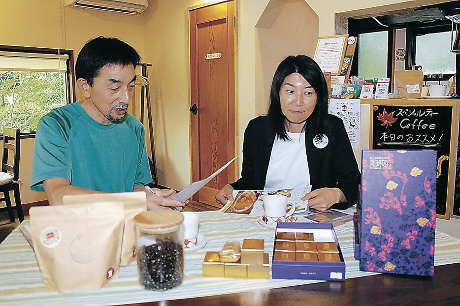 千枚田ＣＯＦＦＥＥとパイナップルケーキのセット販売に向けて打ち合わせる古源さん（左）とシーさん＝野々市市末松１丁目