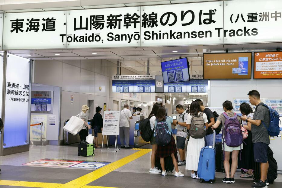 東海道新幹線が運転見合わせとなり、JR東京駅の改札前で待つ人たち＝22日午前