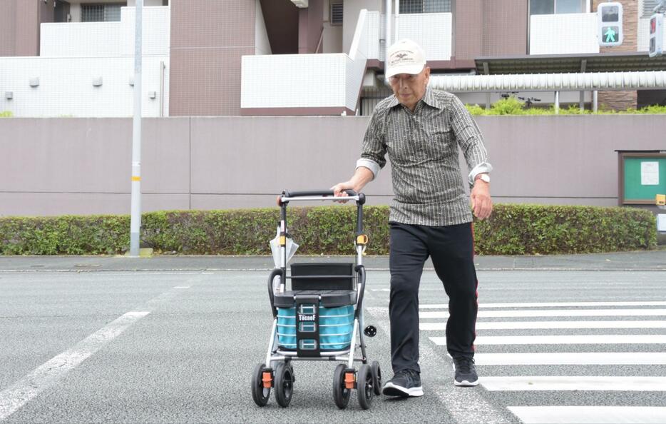 横断歩道を渡る稲村さん。外出先ですれ違う子どもからあいさつされると「自分の存在が認められたようでうれしい」という