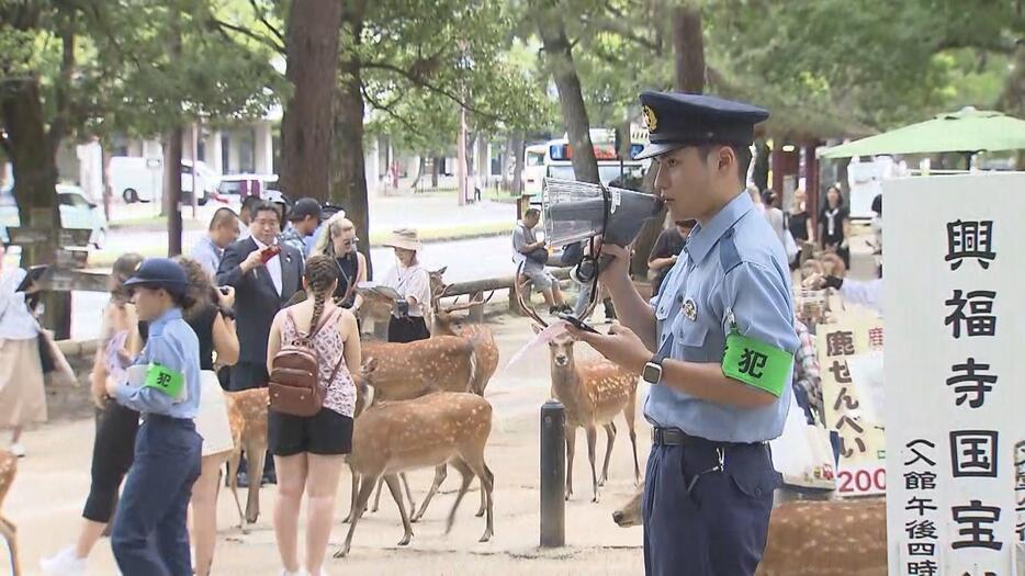 中国語などで警戒呼びかける警察官