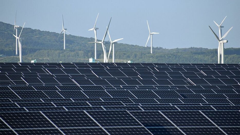 風力発電の風車と太陽光発電のパネル＝2024年5月21日、青森県六ケ所村（時事）