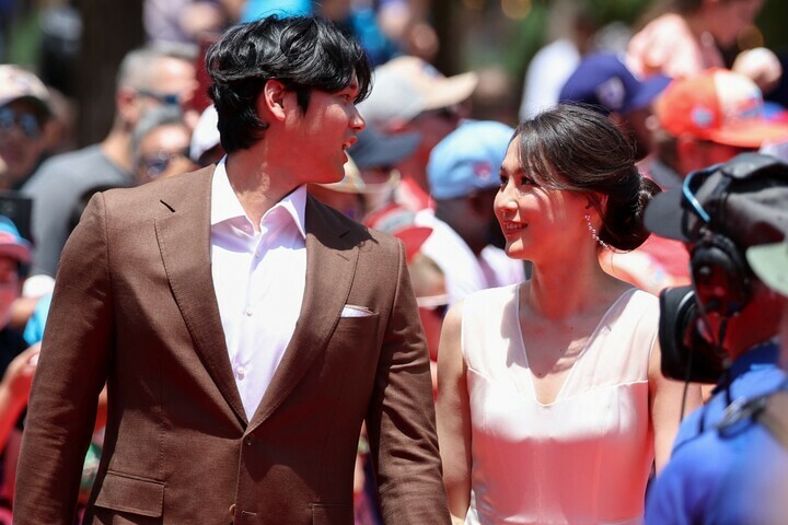 手を繋いで見つめ合う大谷（左）と真美子さん（右）。(C)REUTERS/AFLO