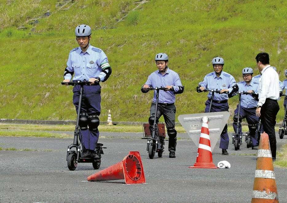 電動キックスケーターに乗り、交通ルールなどを確認する警察官たち（滋賀県日野町で） 記事を読む