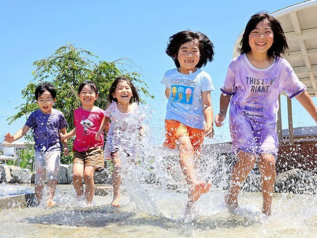 青空の下、水辺で遊ぶ子どもたち＝道の駅ＫＯＫＯくろべ