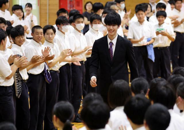 母校の日南振徳高であった五輪壮行会に出席し、在校生の拍手を受けながら入場する甲斐優斗選手＝５日午後、日南市