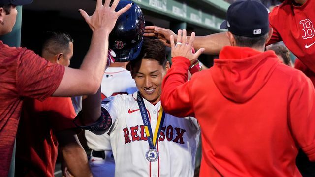 笑顔でチームメイトからの祝福を受ける吉田正尚選手【写真：AP/アフロ】