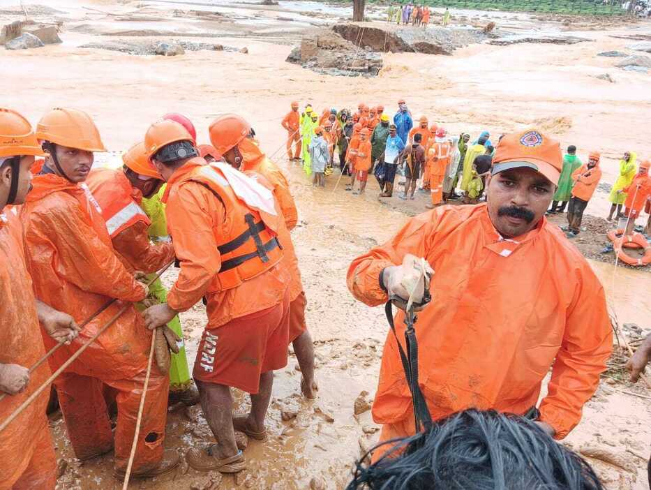 30日、インド南部ケララ州ワイナードで、土砂崩れ発生後に救助作業に当たる人たち（インド国家災害対応隊提供、ゲッティ＝共同）