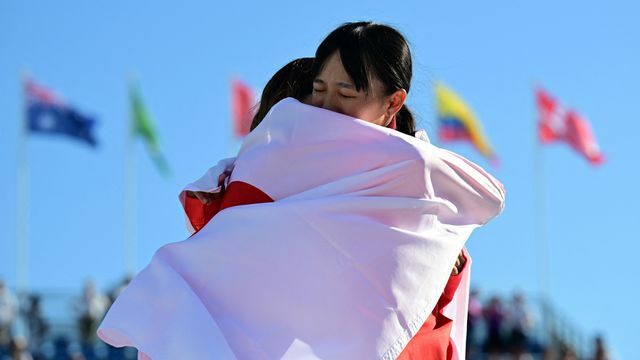 表彰式で抱擁する14歳の吉沢恋選手と15歳の赤間凛音選手(写真:ロイター/アフロ)