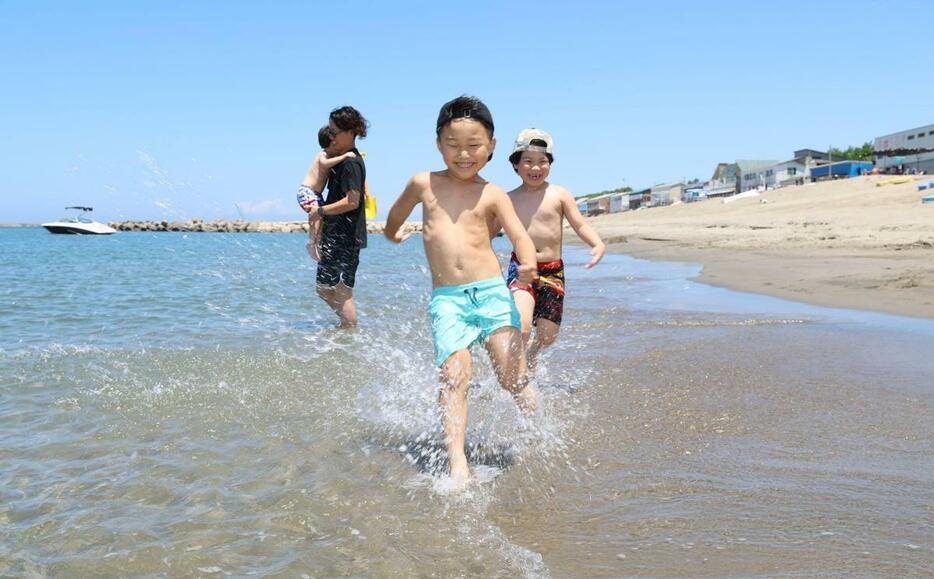 安全祈願祭が行われた関屋浜海水浴場。子どもたちが波打ち際を駆け回っていた=29日、新潟市中央区関屋