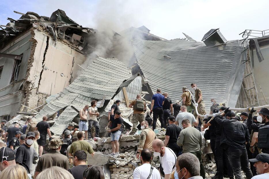 8日、ロシアの攻撃を受け一部建物が崩壊したウクライナ・キーウの小児病院。多くの人々が救助活動に当たった（共同）