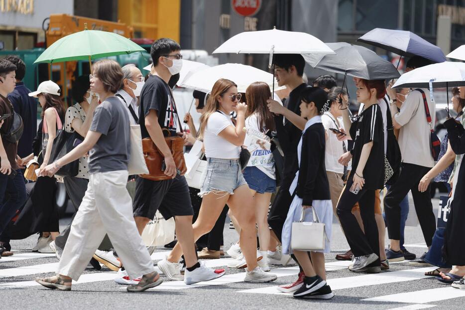 厳しい暑さの中、東京・銀座を行き交う人たち＝6日午後