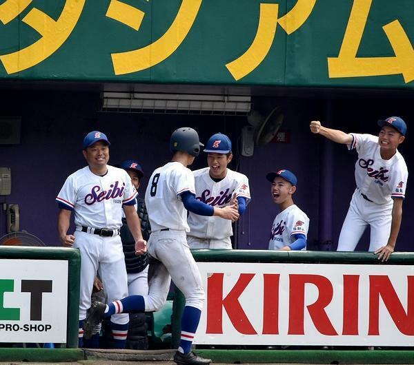 今夏4回戦の北嵯峨戦で、本塁に帰還した選手を迎える井本さん（左）