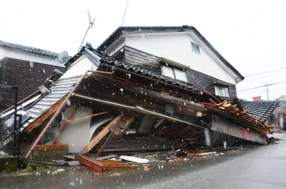 上層階に１階部分がつぶされた家屋＝１月２３日、石川県輪島市