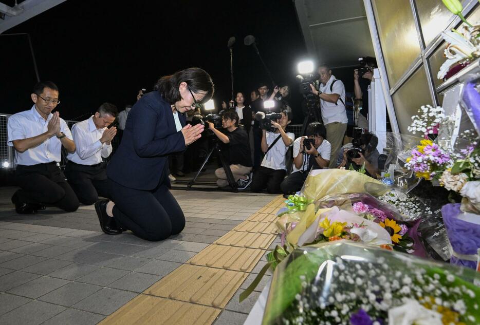 兵庫県明石市の歩道橋事故から23年となり、現場の慰霊碑に献花し手を合わせる丸谷聡子市長＝21日夜