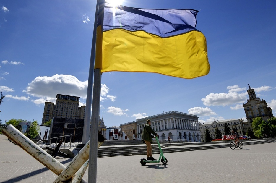 首都キーウの独立広場付近で、風にたなびくウクライナ国旗＝2022年（共同）